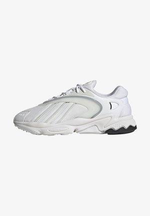 Biały sportowy sneaker z siateczkowymi i skórzanymi panelami, wiązaniem na sznurówki, wyściełaną podeszwą i czarnym gumowym detalem na spodzie.