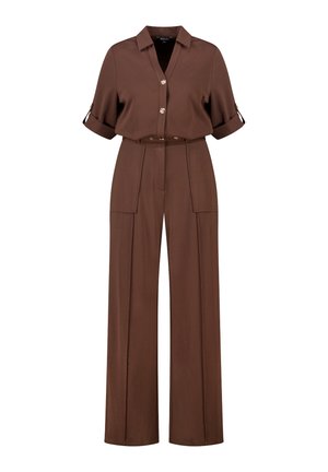 Chemise marron à boutons avec manches retroussées, associée à un pantalon à jambes larges avec poches avant et taille ceinturée. Texture de tissu lisse.