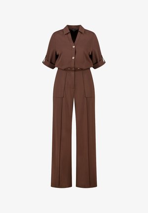 Chemise marron à boutons avec manches retroussées, associée à un pantalon à jambes larges avec poches avant et taille ceinturée. Texture de tissu lisse.