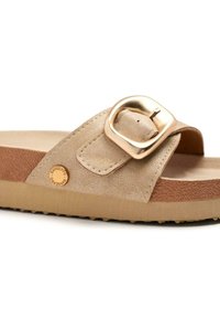 Sandale à glissière beige avec un dessus texturé, dotée d'une large boucle dorée. Semelle intérieure douce et semelle en caoutchouc avec un motif antidérapant.