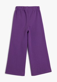 Paarse wijde pijpen van zacht materiaal, met een elastische tailleband en een gladde textuur zonder opvallende patronen of accenten.