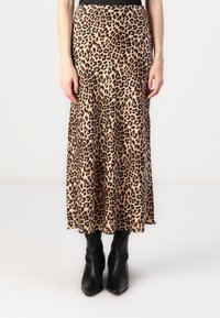 Maxi nederdel med leopardprint lavet af letvægtsstof, med en tætsiddende talje og en flydende silhuet. Båret med sorte ankelstøvler.