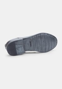 Suola di scarpa in gomma nera con superficie di presa testurizzata, scanalature per trazione e logo del marchio impressionato vicino al tallone. Taglia 42 indicata.