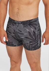 Čierne a šedé plavky s listovým vzorom, vyrobené z elastického materiálu, s priliehavým strihom a bielym logom O'Neill na boku.