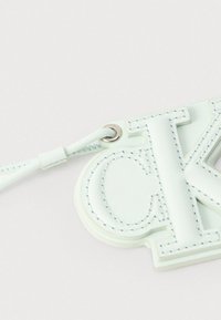 Porte-clés en cuir bleu clair avec les initiales Calvin Klein cousues et une boucle de sangle attachée.