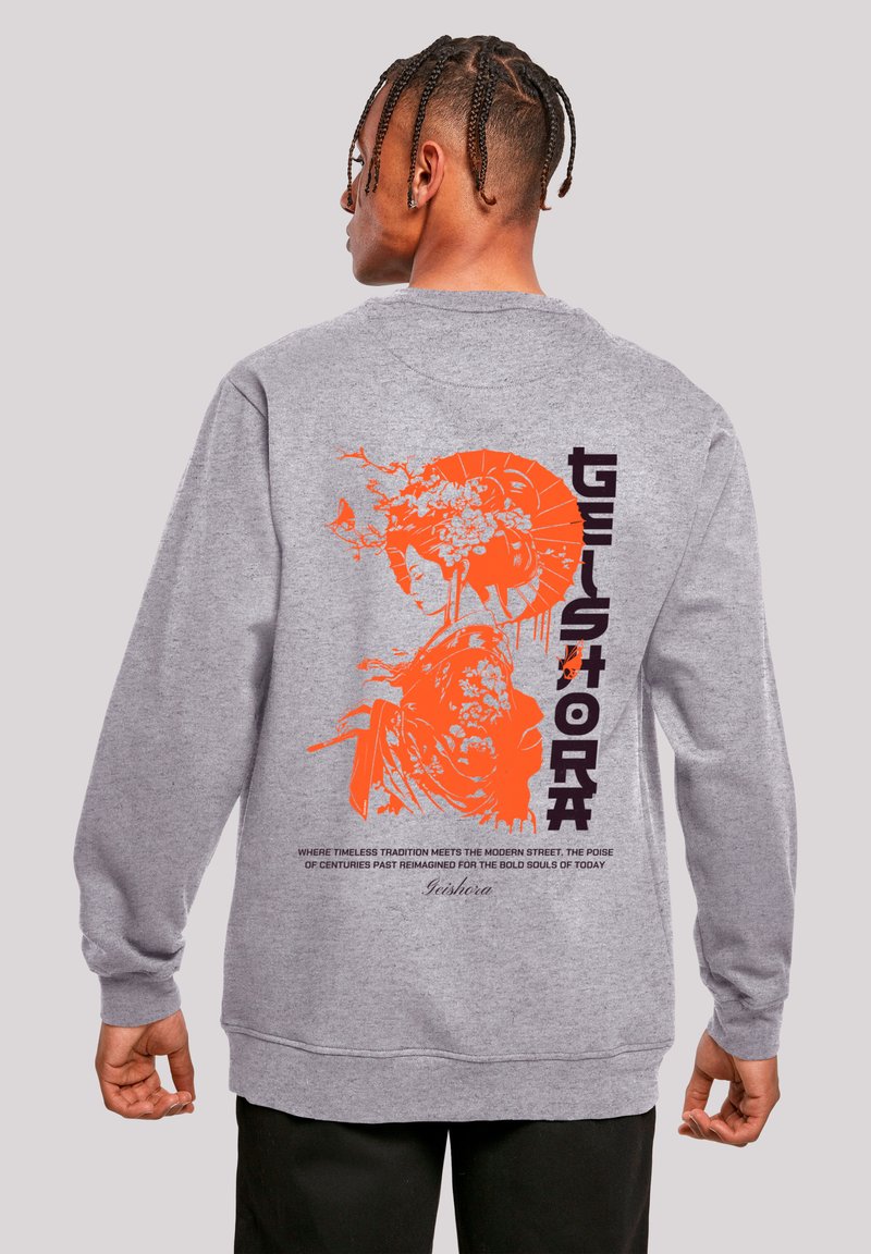 Gray sweatshirt featuring an orange graphic design on the back, depicting a traditional figure. Text in black with notable design details.