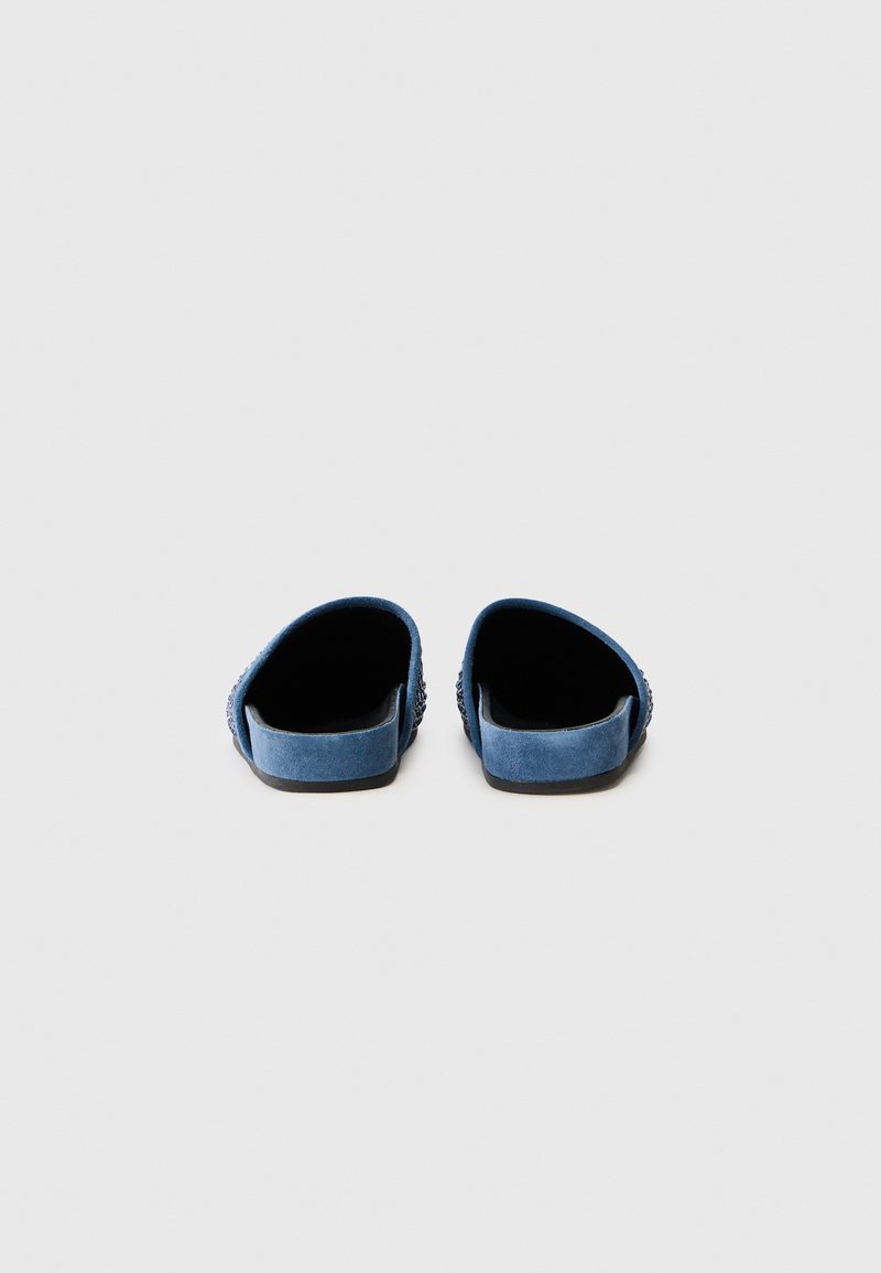 Blauwe suède instapschoenen zonder rug, met een platte zool, featuring een gestructureerd patroon aan de zijkanten en een gladde binnenvoering.