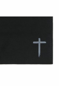 Black fabric corner with stitched edges and a small, simple grey cross painted near the bottom right side.