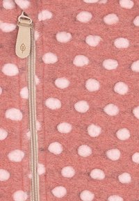 Giacca in pile con zip di colore rosa morbido, decorata con pois bianchi, presenta una zip silver e una superficie in tessuto morbido e strutturato.
