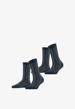 Chaussettes bleu marine en lot de quatre avec un motif géométrique en gris clair, dotées de bords côtelés et d'une texture lisse.