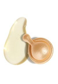 Capsula dorata scintillante per la cura della pelle accanto a una goccia di siero liscia e trasparente su sfondo bianco.