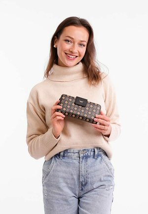 Černá peněženka se zlatým květinovým vzorem, obdélníkového tvaru, hladkého povrchu a s detailním logem, držená osobou v krémovém svetru.