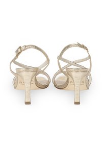 Złote sandały na wysokim obcasie z teksturowanym metalicznym wykończeniem, regulowanymi paskami w kostce i otwartym noskiem. Niski, smukły obcas.