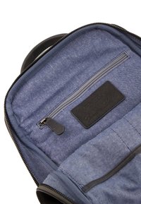 Niebieska tkaninowa wyściółka torby z zamykaną kieszenią, czarną skórzaną metką z napisem "VENETIAN Genuine Leather" oraz ciemnym zamkiem błyskawicznym.