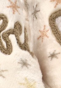 Manta cremosa y exuberante con patrones de copos de nieve en colores suaves, con un acento tejido trenzado verde texturizado. Tela acogedora y suave.