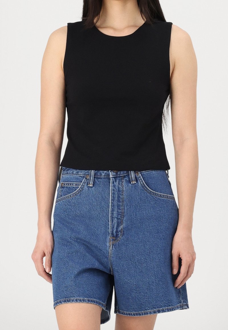 Black sleeveless top with a rounded neckline, paired with high-waisted blue denim shorts featuring two front pockets and a straight cut.