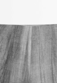 Tissu en lin gris avec une surface texturée, présentant des plis subtils et une finition naturelle. La disposition montre deux coutures verticales.