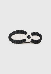 Sneaker sole featuring a segmented black rubber tread, a white midsole, and a prominent diamond pattern in the center.