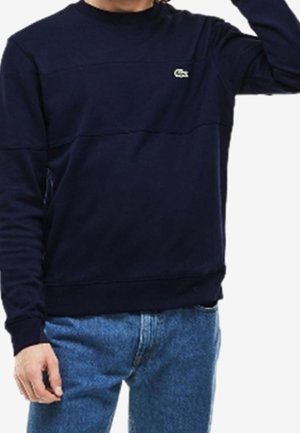 Sudadera azul marino hecha de una mezcla de algodón, con cuello redondo, puños acanalados y un pequeño logo verde en el pecho.