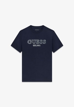 Marineblå bomuldst-shirt med teksten "GUESS" i lyseblå broderi og "EST.1981" nedenunder i en afslappet skrifttype. Kortærmet, rund hals.