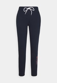 Marinblå mjukisbyxor i mjukt tyg, med elastisk midja och vit dragsko samt en liten röd logodetalj på nedre benet.