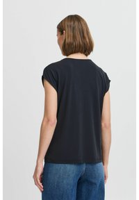 Black, short-sleeve top with a round neckline. Smooth texture, relaxed fit, and cuffed sleeves. Worn with blue jeans, viewed from the back.