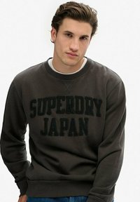 Ciemnoszara bluza z mieszanki bawełny, z napisem "SUPERDRY JAPAN" w grubych czarnych literach. Okrągły dekolt i ściągacze na rękawach.