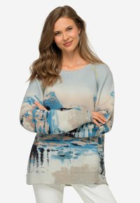 Sweter wełniany z wzorem krajobrazowym w kolorach niebieskim, beżowym i czarnym, o luźnym kroju, prążkowanej fakturze i długich rękawach.