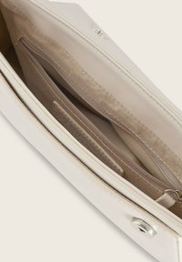Witte synthetische handtasinterieur met een beige voering, voorzien van een ritsvak en een insteekvak, evenals een magneetsluiting.