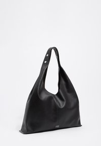 Čierna kožená taška s mäkkým, zaobleným tvarom a otvoreným vrchom. Obsahuje dve uchopovacie rúčky so striebornými cvokmi na jednej strane.