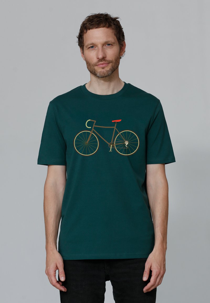 Donkergroen t-shirt met een gouden fietsafbeelding en een rode zitting, ronde halslijn, korte mouwen en een losse pasvorm.