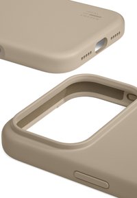 Beige beskyttende smartphone-etui med udsparinger til kamera, opladningsport og knapper, mærket "Ideal of Sweden" på bagsiden.