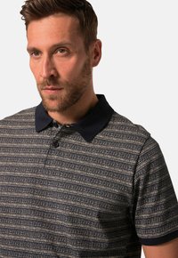 Polo tričko s námořnickými a krémovými pruhy, s pevným námořnickým límcem, zdobené strukturálním vzorem a tříknoflíkovou légou.