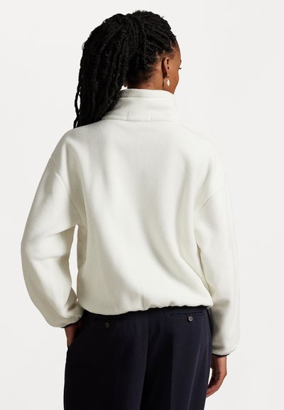 Weißer Fleece-Pullover mit hohem Kragen, lockerem Schnitt und langen Ärmeln. Hat eine weiche Textur und einen leicht eingezogenen Saum.