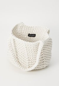 Cesto intrecciato in cotone bianco con un design testurizzato e robusti manici, dotato di una piccola etichetta nera del marchio all'interno.