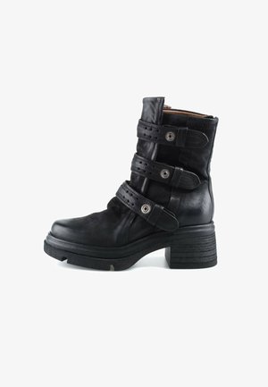 Bottine en cuir noir avec trois sangles réglables et œillets en métal, semelle épaisse et talon carré.