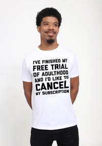 Hvid T-shirt med sort tekst, der læser "JEG HAR AFSLUTTET MIN GRATIS PRØVE AF VOKSENLIVET, OG JEG VIL GERNE ANNULLERE MIN ABONNEMENTER." Casual fit.