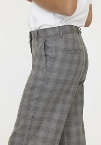 Grijze geruite broek met een getailleerde pasvorm, voorzien van een platte voorkant, een gladde textuur, zijzakken en een enkele achterzak met een knoop.