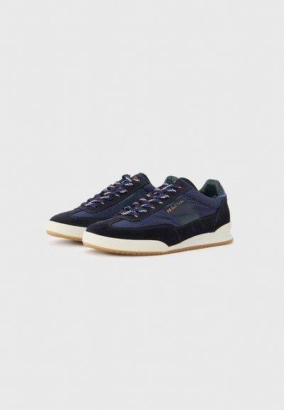 Sneakers blu navy con pelle scamosciata e tessuto strutturato, caratterizzate da lacci colorati, suola a contrasto e dettagli del marchio sul lato.