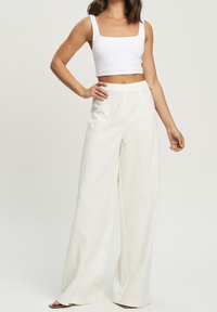 Białe spodnie wide-leg z wysokim stanem i czystym designem, wykonane z lekkiego materiału. Posiadają kieszenie boczne i gładką teksturę.