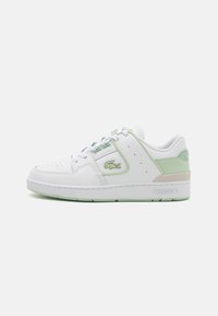 Baltas ādas sporta apavu modelis ar piparmētru zaļiem akcentiem, apaļa purngala forma, perforēts dizains, ar saistēm aizverams un strukturēts zole. Lacoste logo sānos.