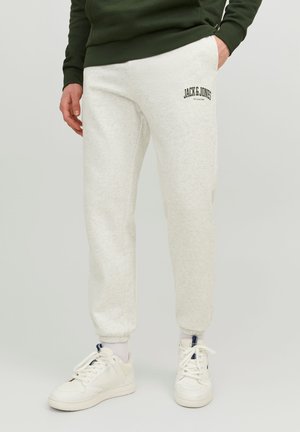Light gray jogger pants with cuffed ankles and an embroidered "JACK & JONES" logo. Made from soft fabric, paired with white sneakers.