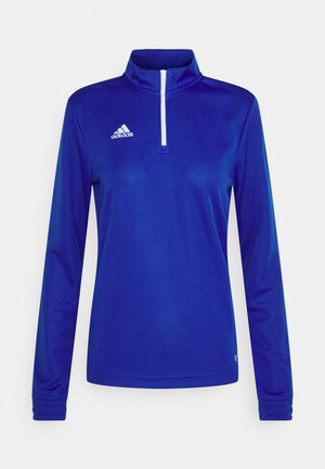 Blauwe sportieve half-zip top met lange mouwen, gemaakt van een gladde stof. Bevat een witte rits en een logo-accent op de linkerborst.