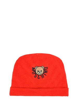 Bonnet en coton rouge avec un revers, présentant un graphisme d'ours et le mot "Moschino" en lettres noires épaisses autour.