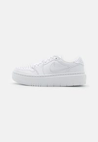 Baskets en cuir blanc avec une surface texturée, un bout perforé, une semelle épaisse et un logo Nike discret sur le côté. Design minimaliste.