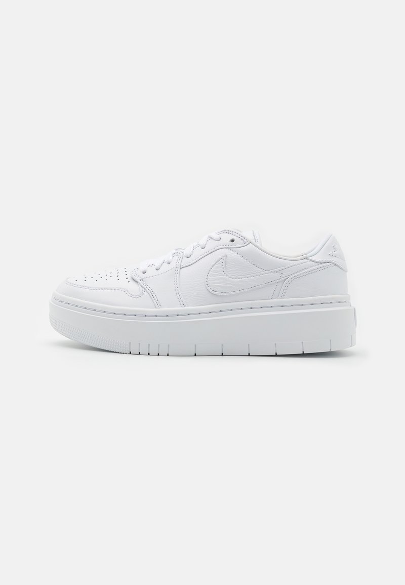 Baskets en cuir blanc avec une surface texturée, un bout perforé, une semelle épaisse et un logo Nike discret sur le côté. Design minimaliste.