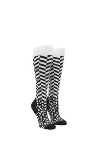 Chaussettes montantes présentant un motif rayé noir et blanc sur le haut et une base noire avec un design léopard blanc. Matériau doux.