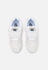 Tenisi albi din suede cu sireturi albe, cu un vârf perforat, guler căptușit și logo-ul Vans pe limbă. Talpă din cauciuc plat. Design minimalist.