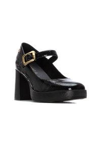 Zapatos de charol negro estilo Mary Jane con un grueso tacón cuadrado, punta redonda y una correa ajustable con hebilla dorada. Acabado texturizado.