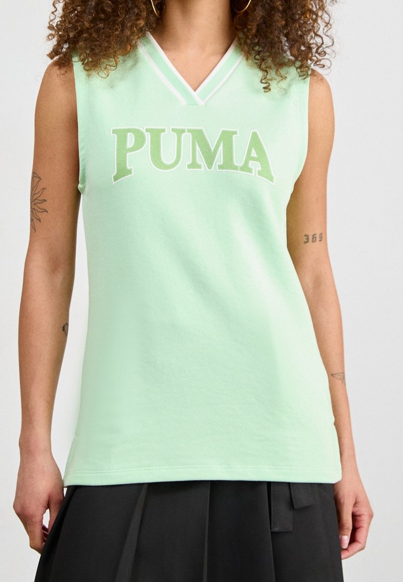 Mintgrön ärmlös topp med V-ringning, som har en djärv vit "PUMA"-logotyp, mjukt tyg och kontrasterande detalj vid halsringningen.